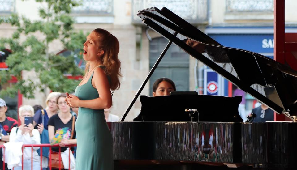 Chanteuse accompagnée d'une pianiste sur la scène d'Opéra sur transat