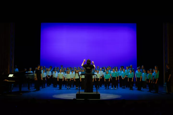 Cheffe de chant devant une chorale d'enfants