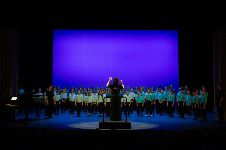 Cheffe de chant devant une chorale d'enfants